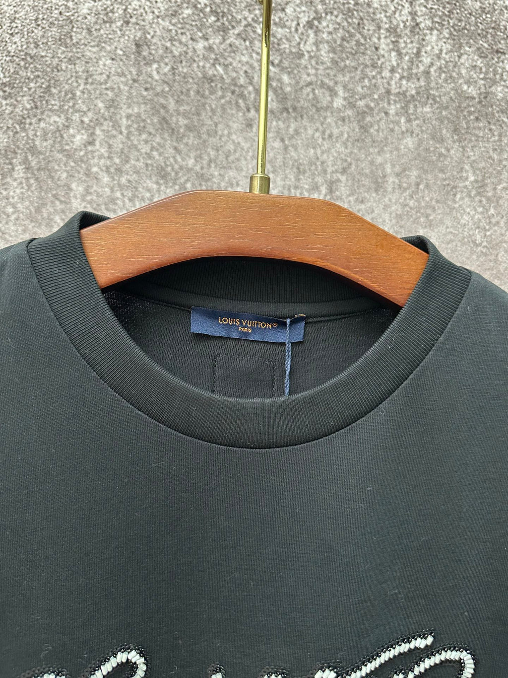Dark crew-neck T-shirt collar with inner Louis Vuitton size label
