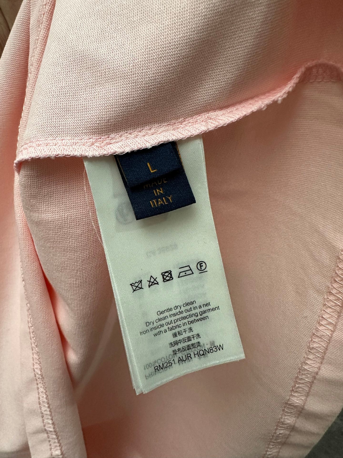 Louis Vuitton fabric care label inside pale pink T-shirt with symbols and sizing