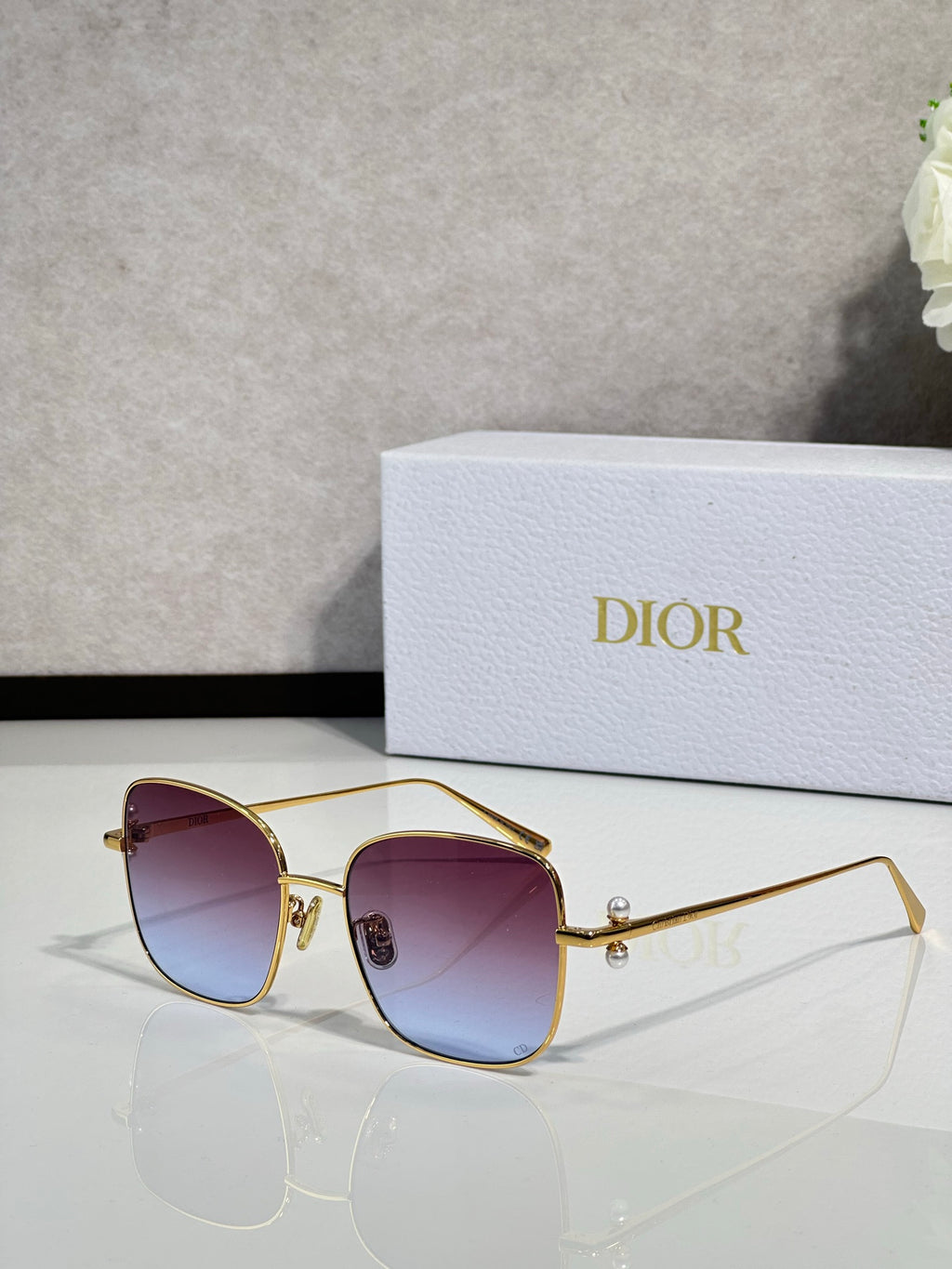 Dior sunglasses with gold-tone frame and purple gradient lenses