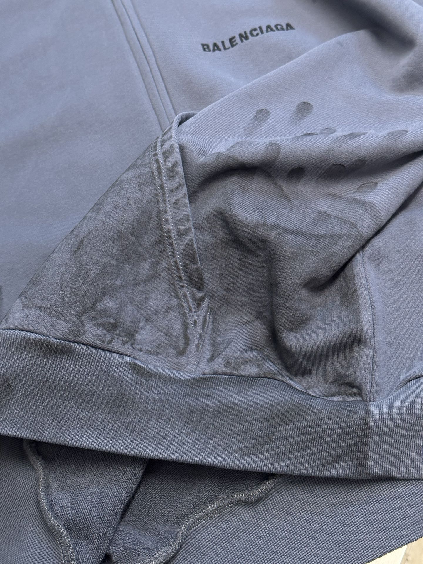 Light blue hoodie close-up of zipper and hood graphic detail near chest
