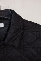Black quilted jacket shoulder with button detail and angled front panel