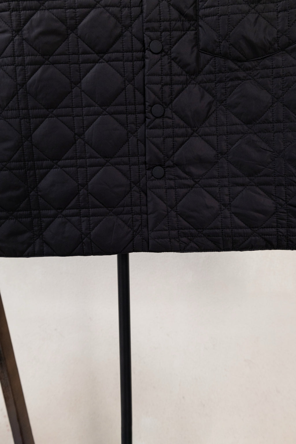 Black quilted jacket back with button placket and diamond stitching