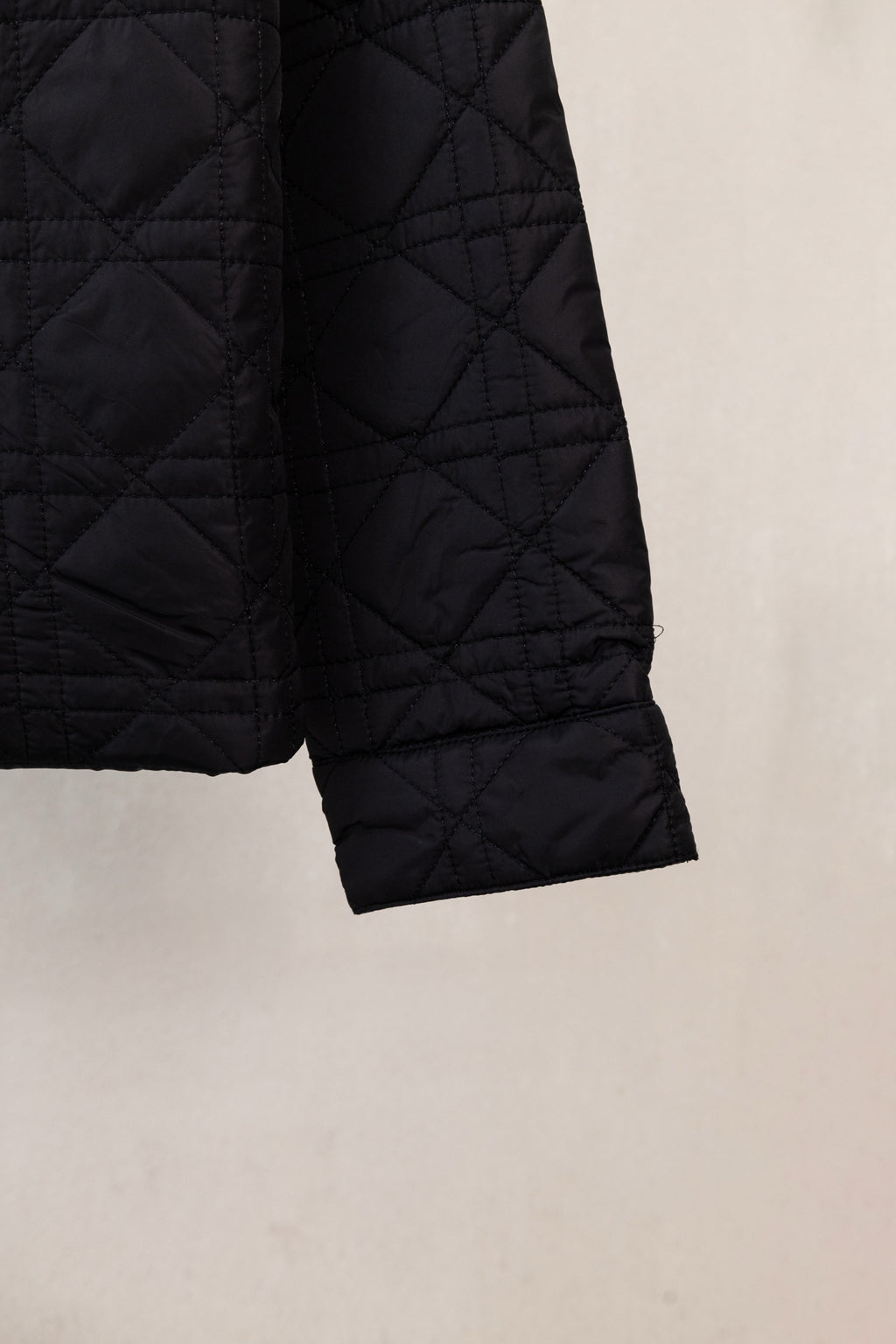 Black quilted jacket sleeve cuff with stitched hem