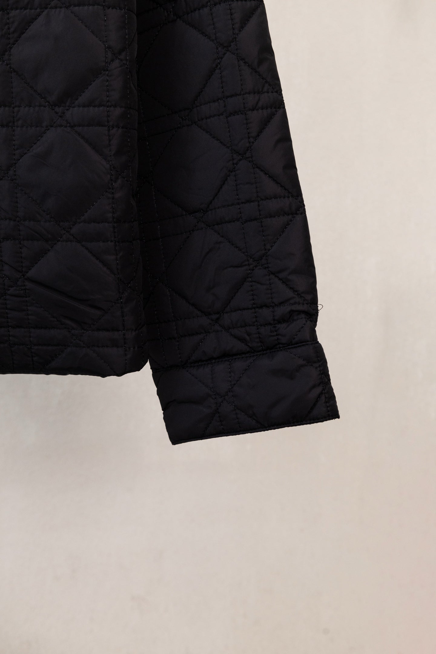 Black quilted jacket sleeve cuff with stitched hem