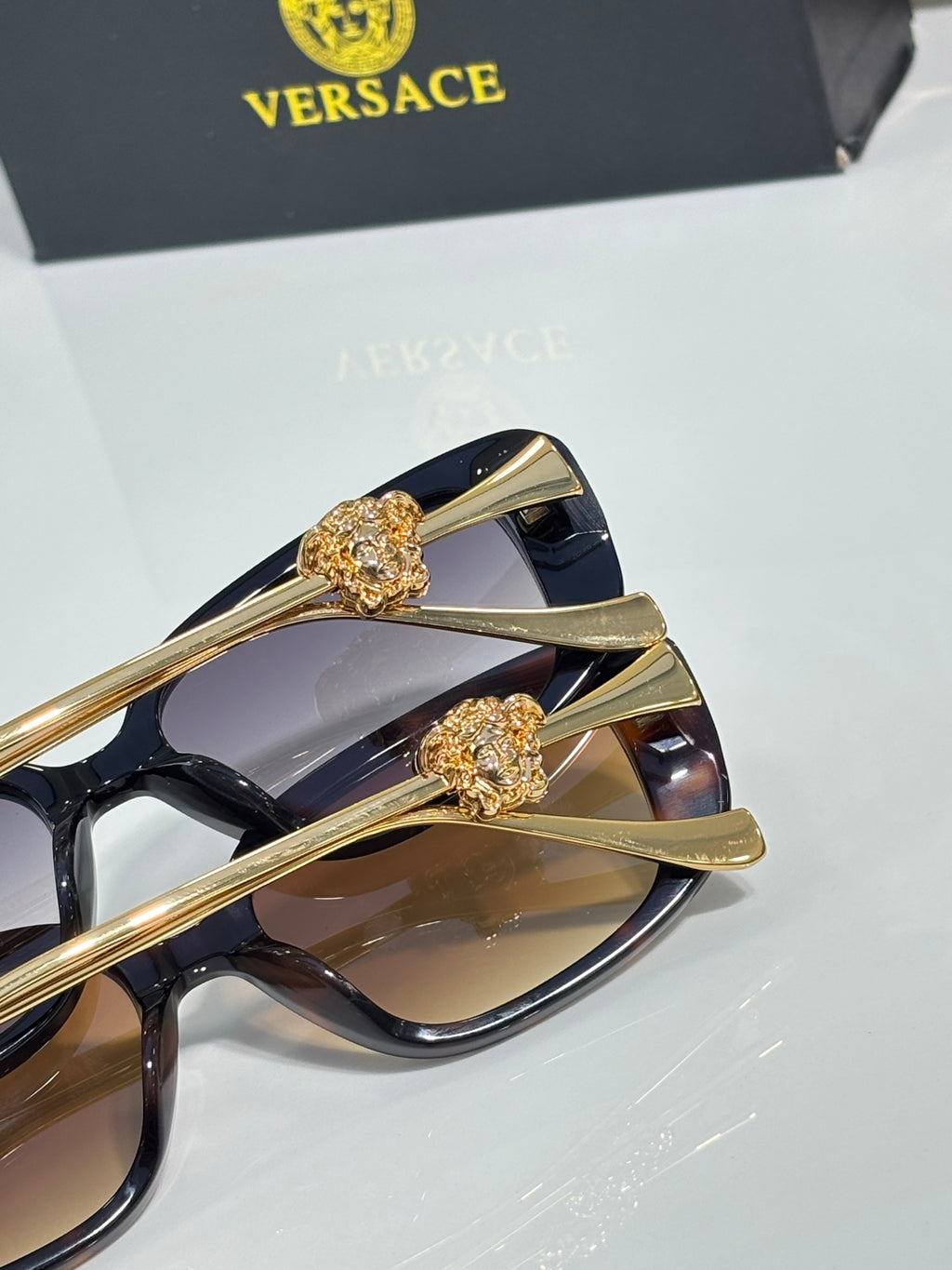 Versace black sunglasses close-up of gold-tone arms with Medusa emblem