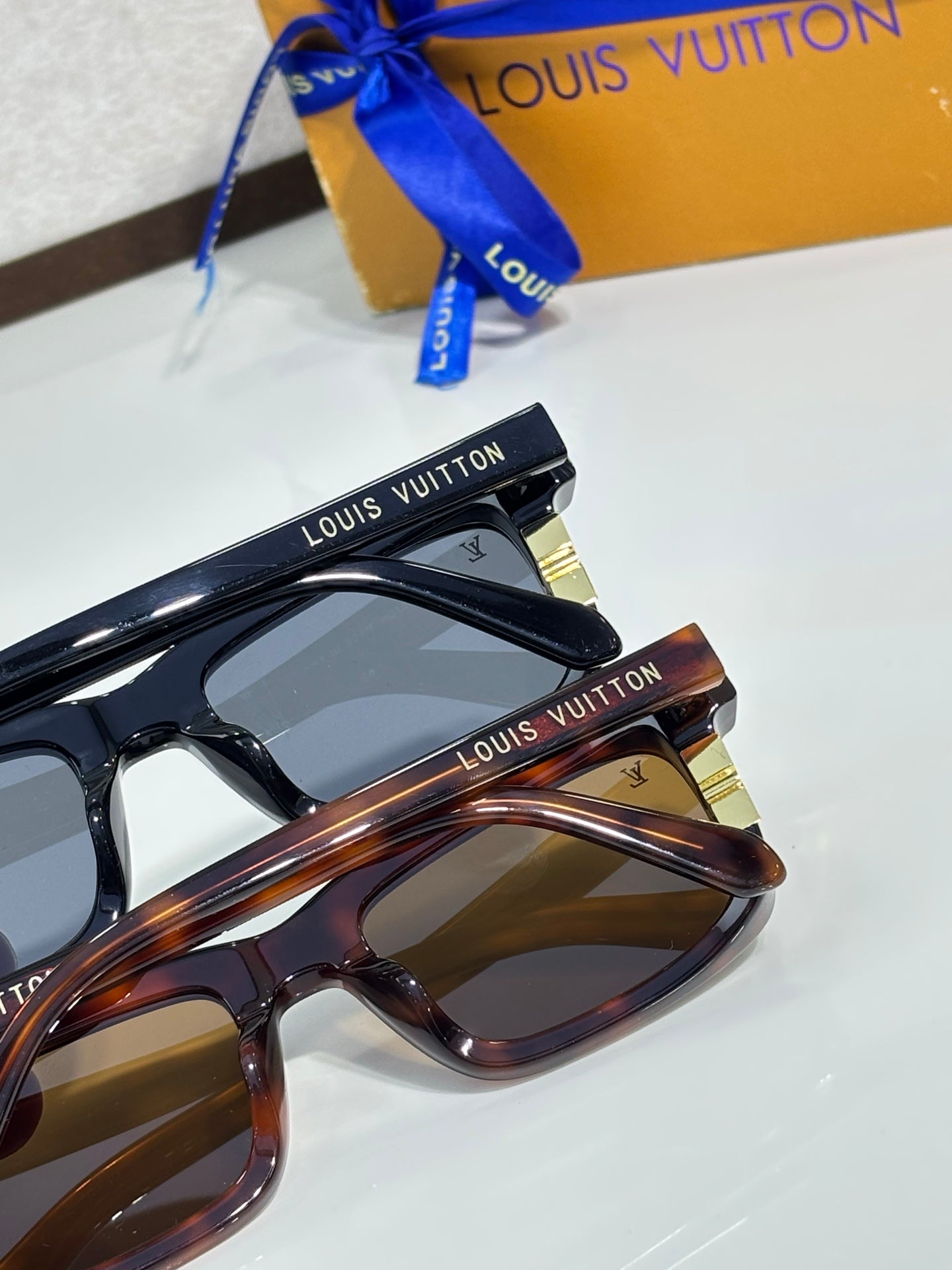 Eyeglasses frames, one dark blue and one tortoise patterned, with tinted lenses