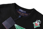 Black T-shirt neckline with blue button and Louis Vuitton neck tag