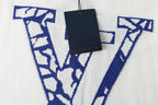 Louis Vuitton T-shirt detail, white fabric with blue LV-style V graphic print