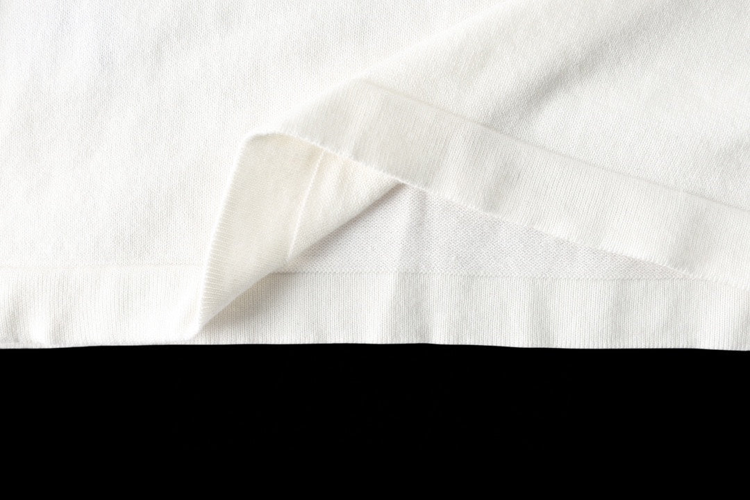 Louis Vuitton T-shirt hem close-up, white fabric with draped fold