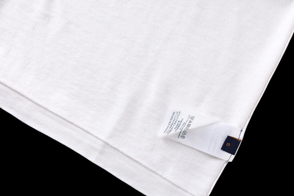 White T-shirt fabric close-up with care label near hem