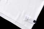 White T-shirt fabric close-up with care label near hem