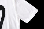 White T-shirt sleeve and hem with partial black graphic print