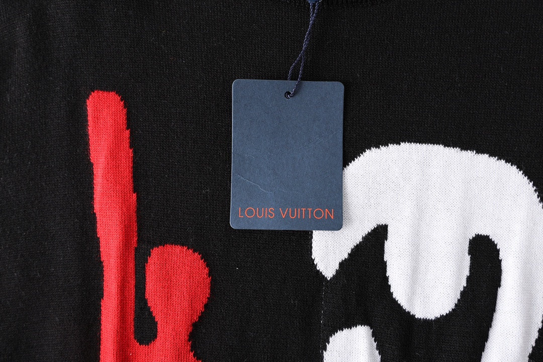 Black T-shirt close-up with hanging blue Louis Vuitton tag and red graphic