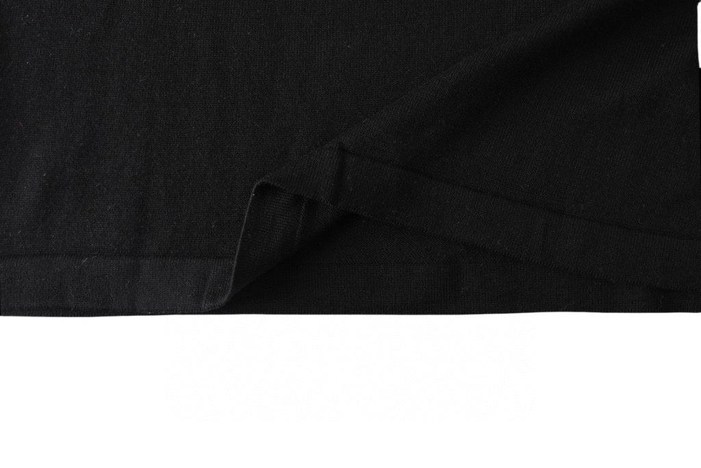 Black T-shirt hem and draped fabric close-up