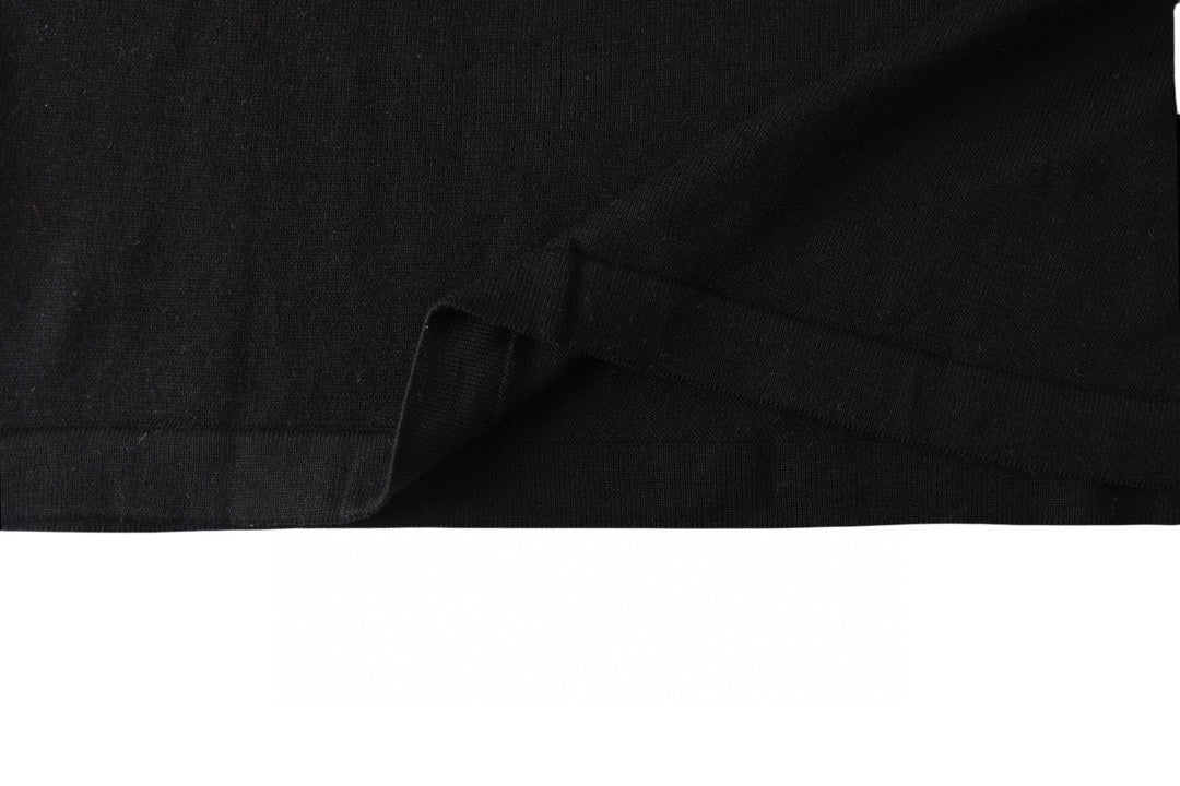 Black T-shirt hem and draped fabric close-up