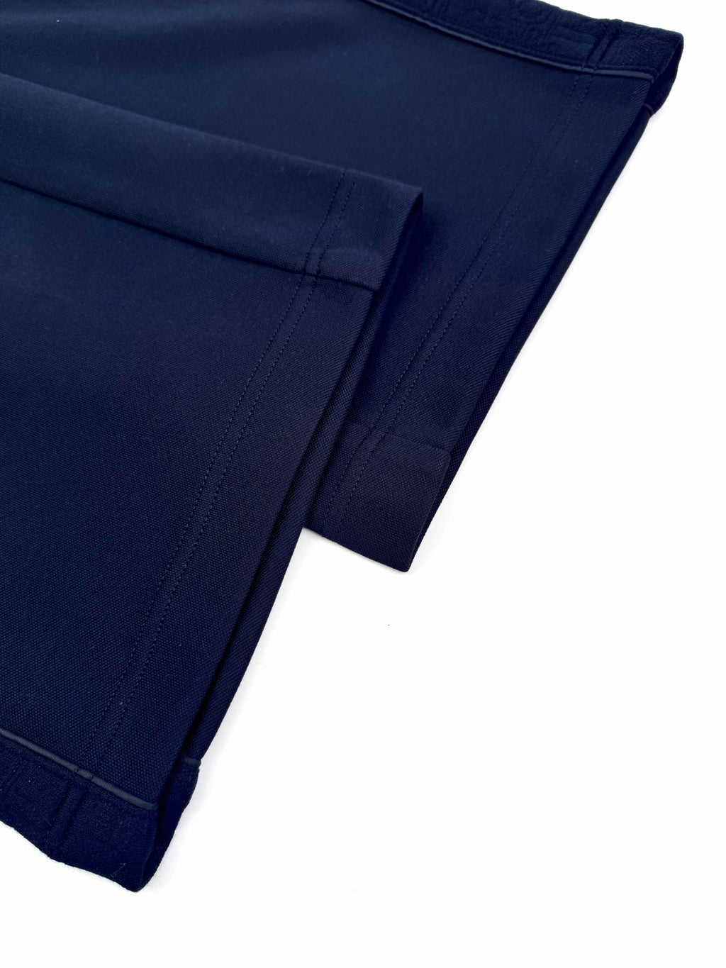 Navy trouser leg hem with stitched back pocket opening