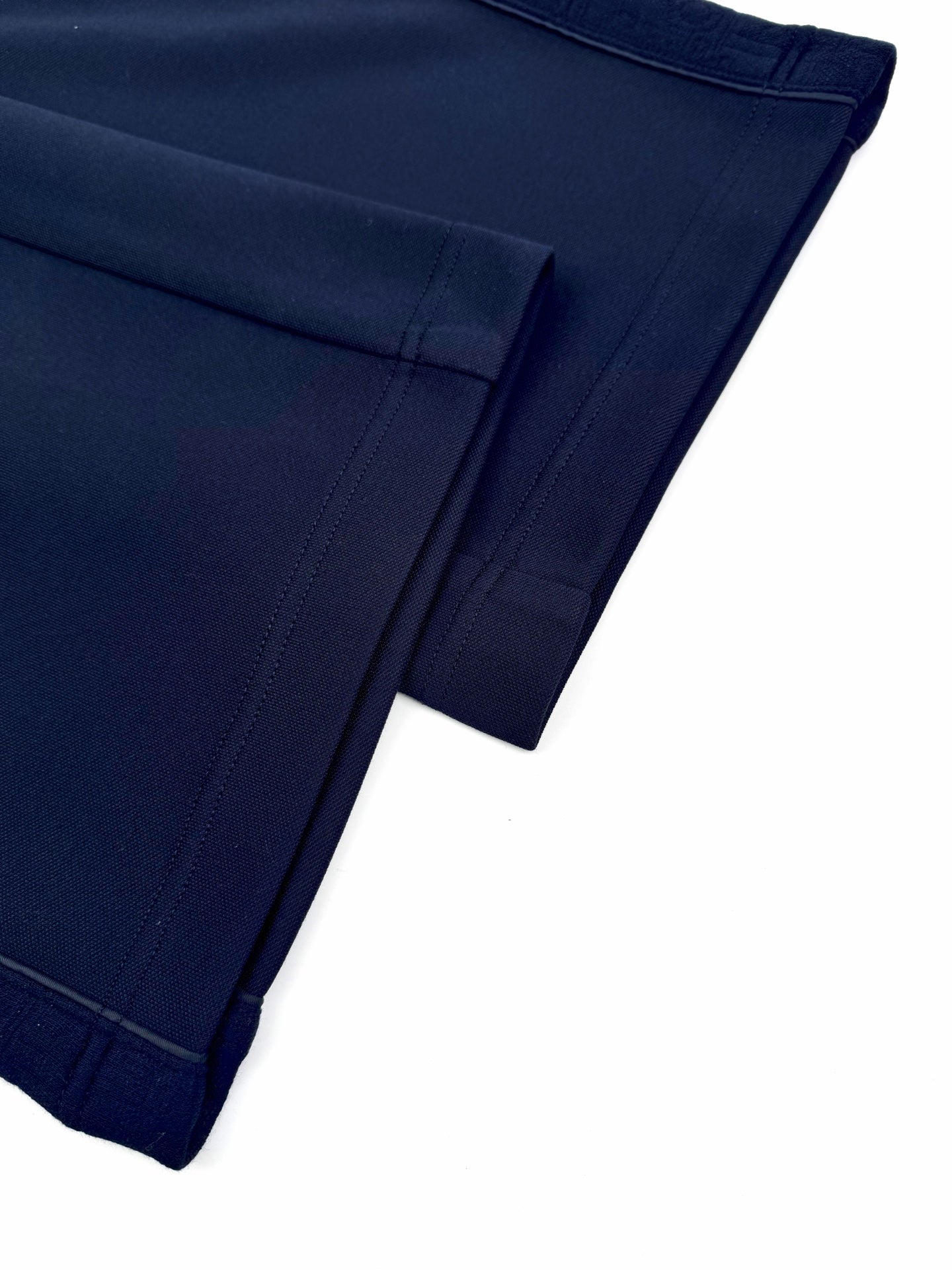 Navy trouser leg hem with stitched back pocket opening