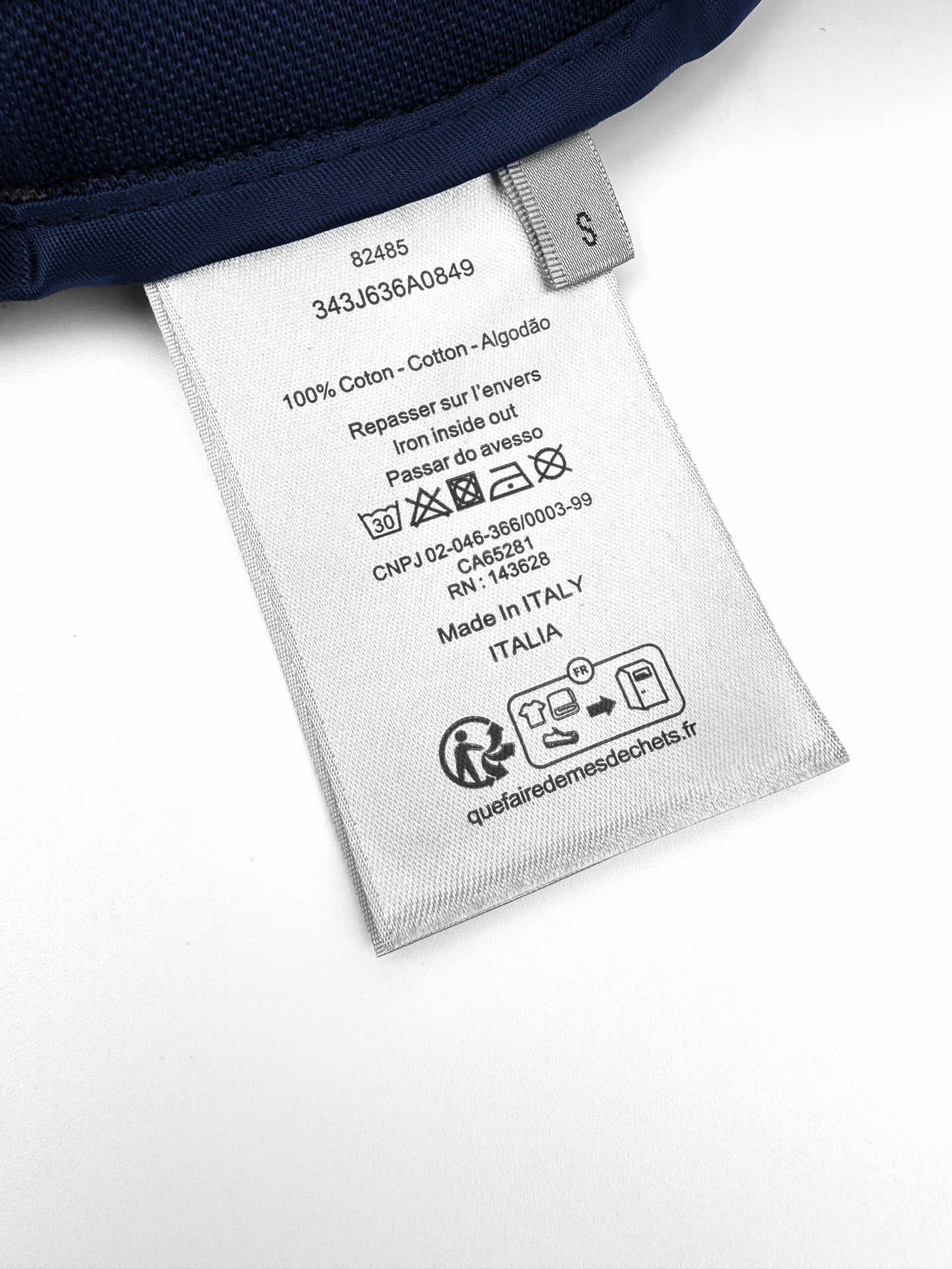 White care label inside pants with fabric composition and washing instructions