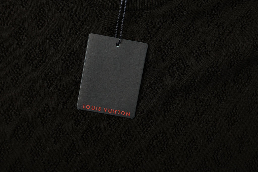Black T-shirt fabric with subtle monogram pattern and hanging logo tag