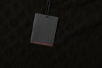 Black T-shirt fabric with subtle monogram pattern and hanging logo tag