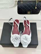 Chanel slingback flats with white flower pom-poms on low heels, maroon lining