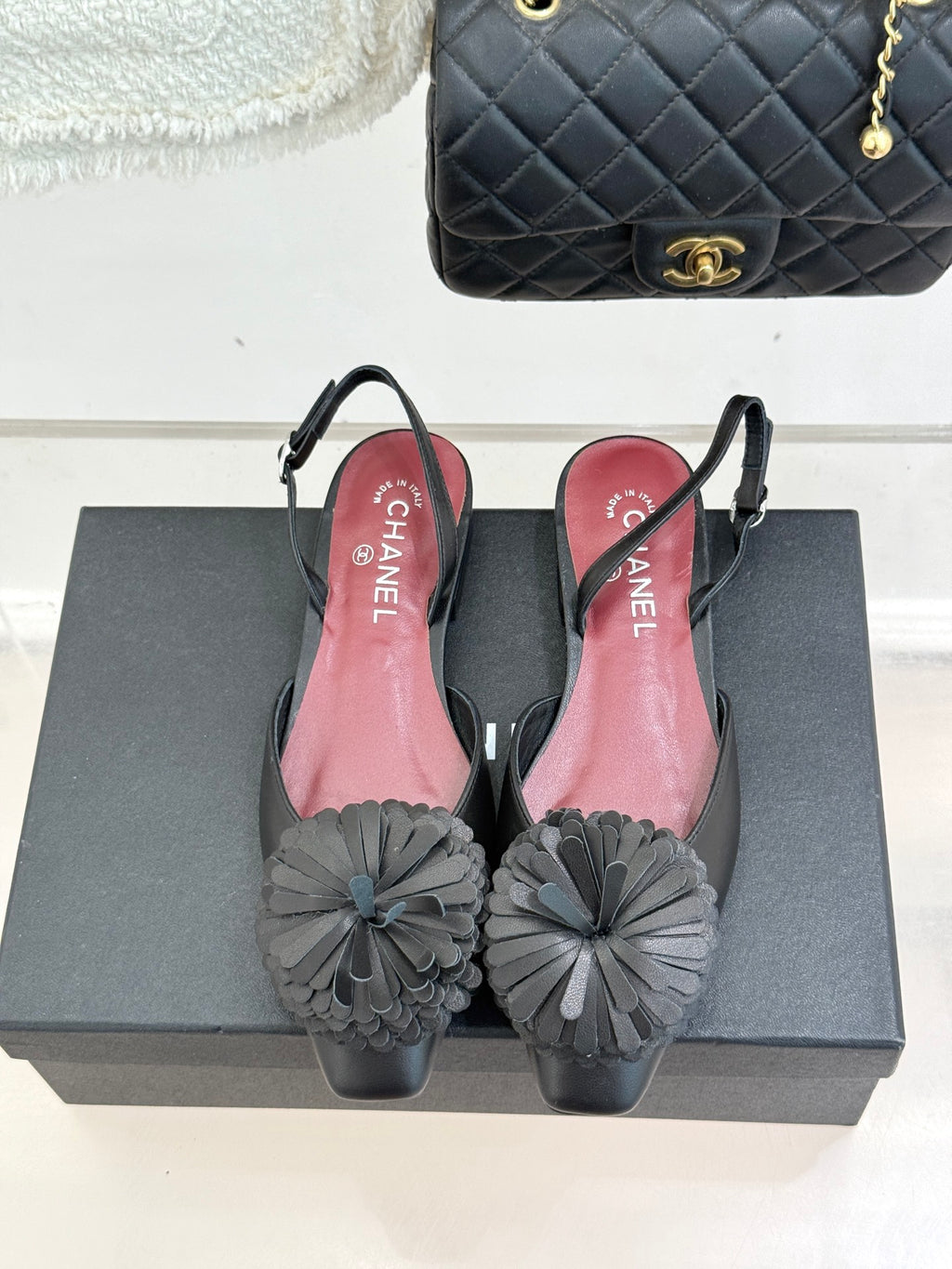Black Chanel slingback flats with gray floral appliqués and pink insoles on box