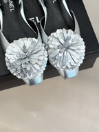 Chanel slingback heels close-up with layered white flower appliques