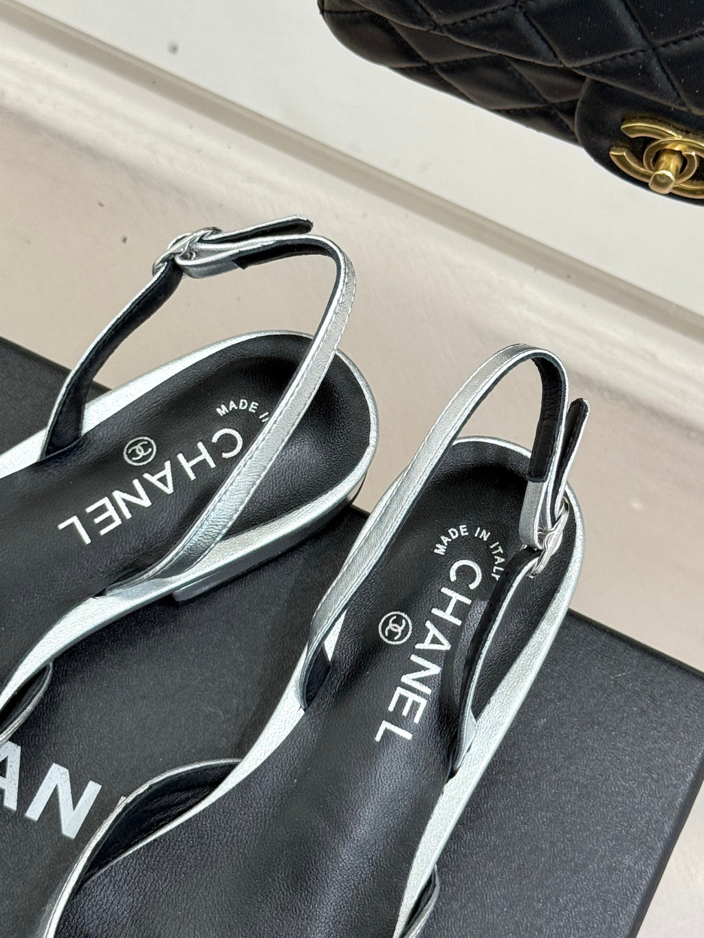 Chanel slingback sandals with silver straps and black footbed lettering