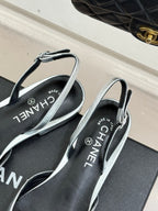 Chanel slingback sandals with silver straps and black footbed lettering