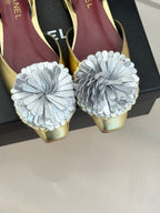 Gold slingback shoes with oversized white flower appliques and pointed toe