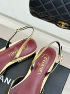 Gold-trimmed slingback flats with “CHANEL” logo lining