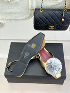 Gold mule flats with white flower appliques and burgundy “CHANEL” lining