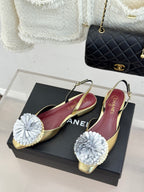 Champagne flats with white flower appliques and gold-trim slingback straps