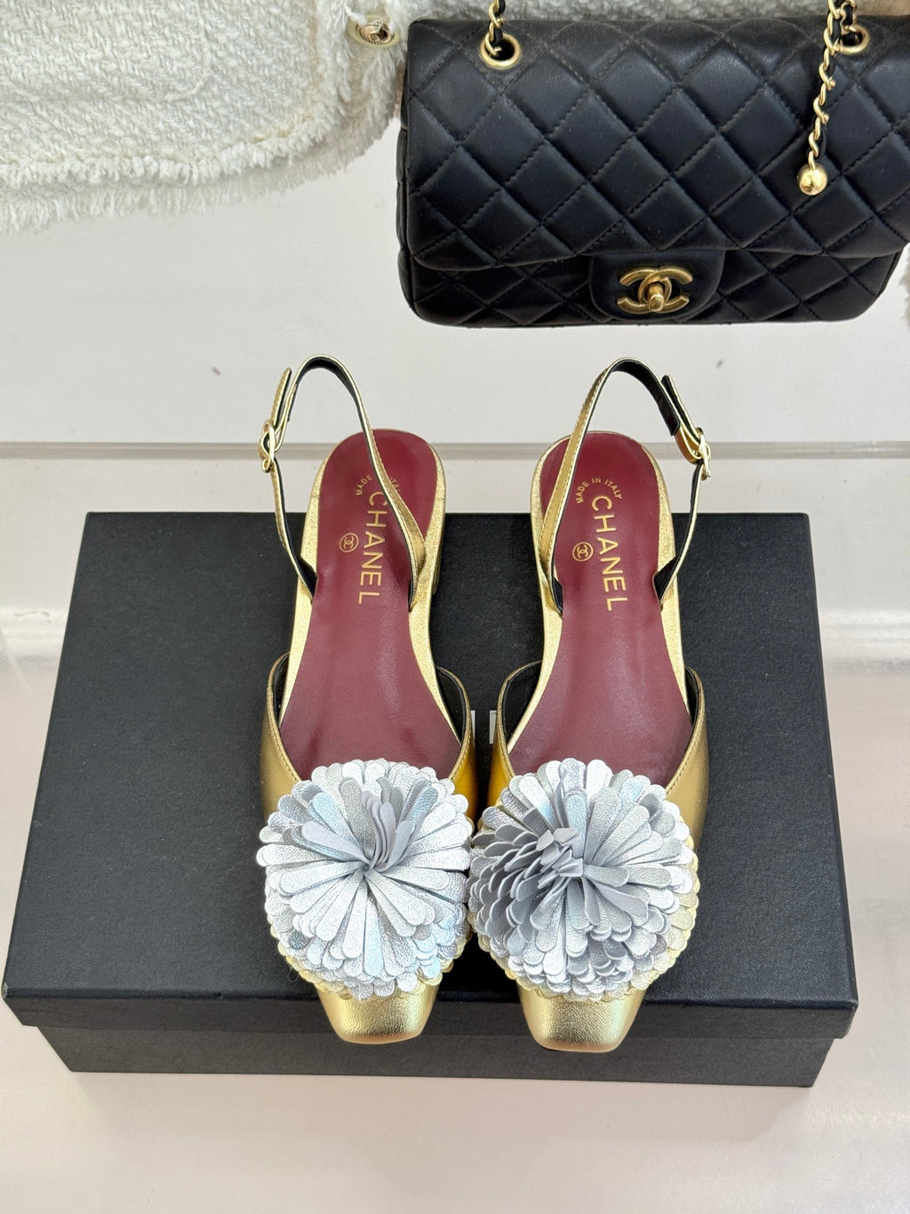 Gold slingback pumps with white flower appliques and slingback straps