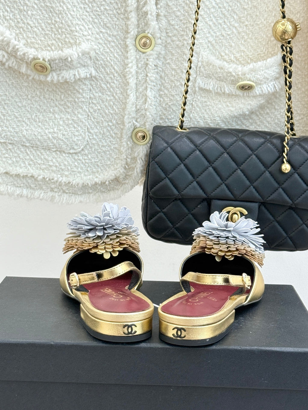 Gold mule flats with large white flower details and slingback straps