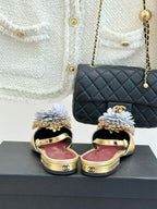 Gold mule flats with large white flower details and slingback straps