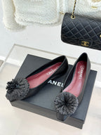 Chanel dark flats with red interior lining and gray flower bow detail