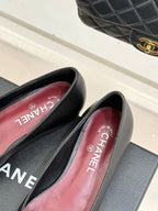 Chanel dark flats with pink CHANEL logo insole, open side view