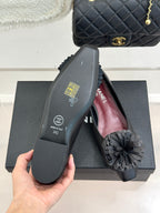 Chanel dark flats sole close-up with gray flower on top