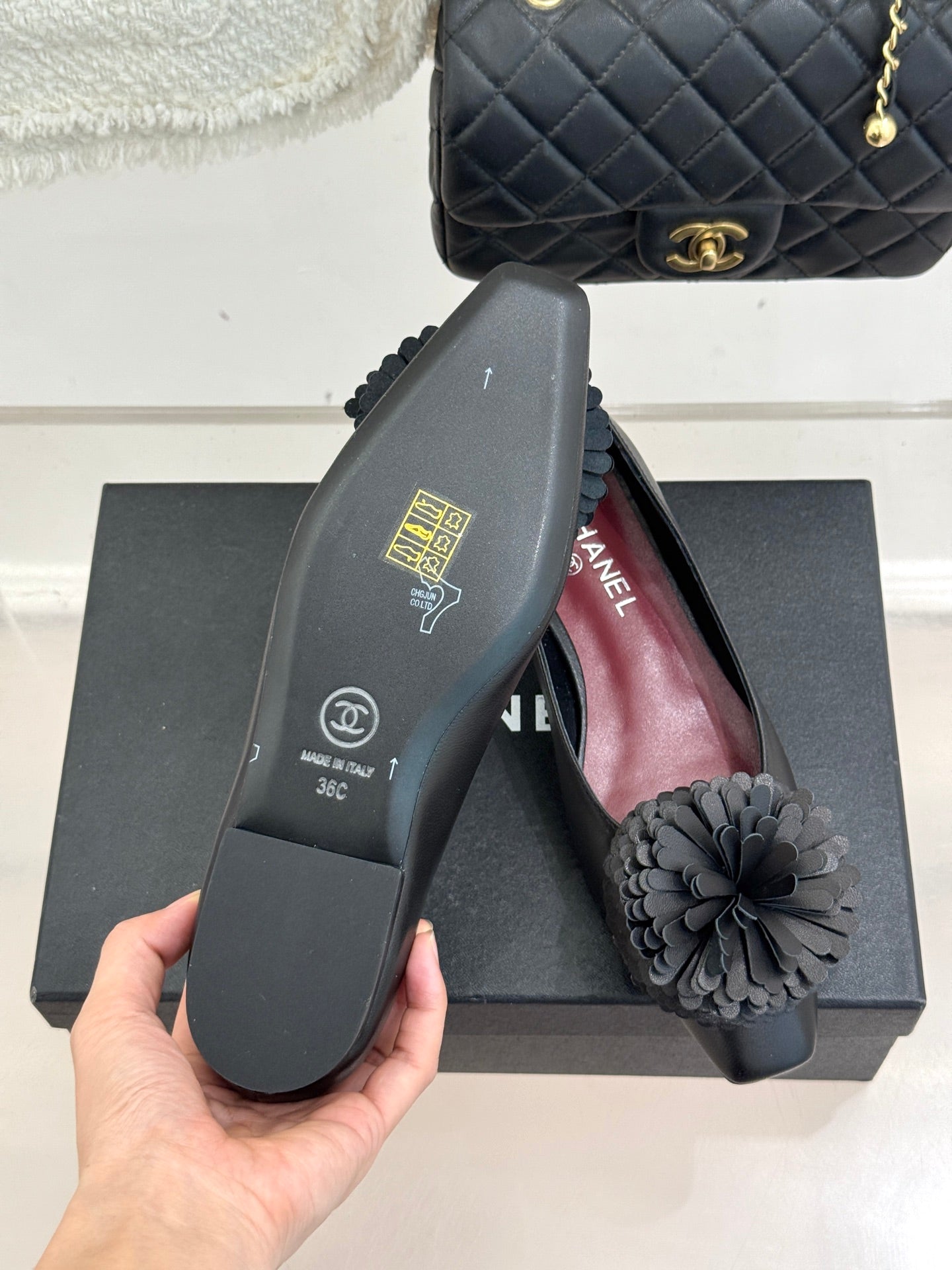 Chanel dark flats sole close-up with gray flower on top