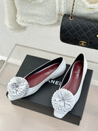 White leather flats with 3D flower appliques and red-toned interior lining