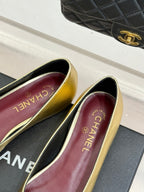 Gold Chanel flat insoles with CHANEL text and burgundy interior, close-up