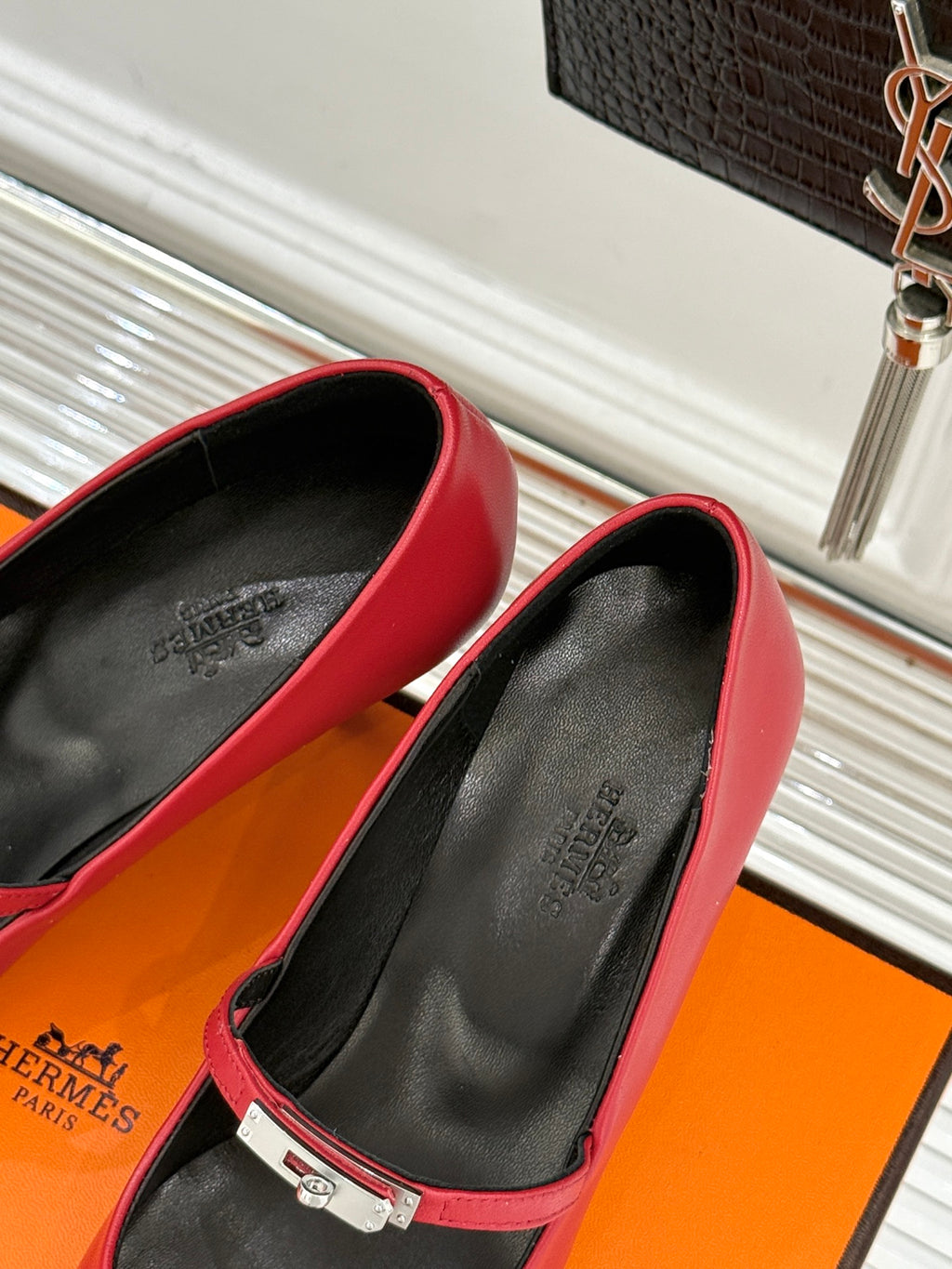 Red pointed-toe pumps with slingback strap, metal buckle, and black insole.