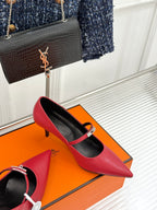 Red pointed-toe heeled pump with slingback strap and metal buckle detail.