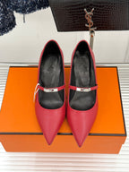 Red pointed-toe pumps with slingback strap and black interior, low heel.