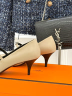 Cream pump with pointed toe, black lining, and mid-height heel