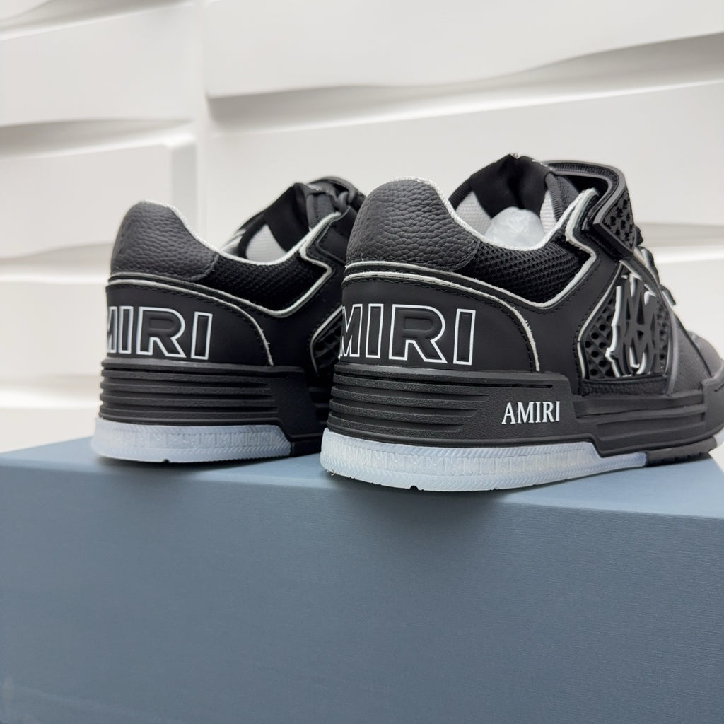 Close-up of black sneakers with AMIRI heel text and textured lace strap