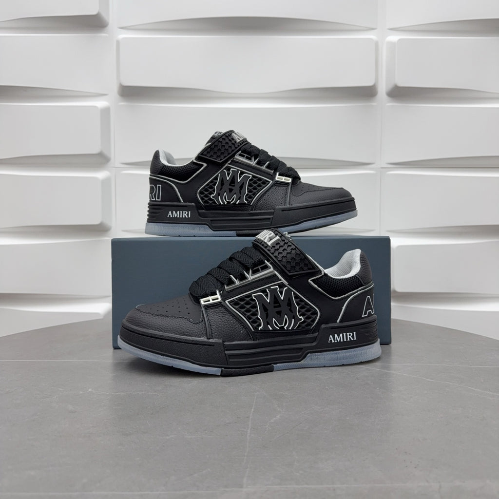 Pair of black low-top sneakers with strap details and side emblem on blue boxes