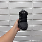Luxury low-top sneaker heel view in black with AMIRI text on the strap