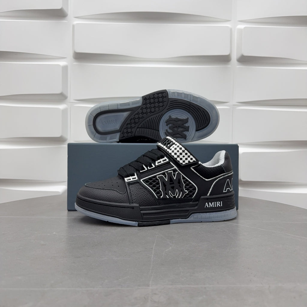 Black low-top sneaker outsole view with checkerboard strap and graphic logo.